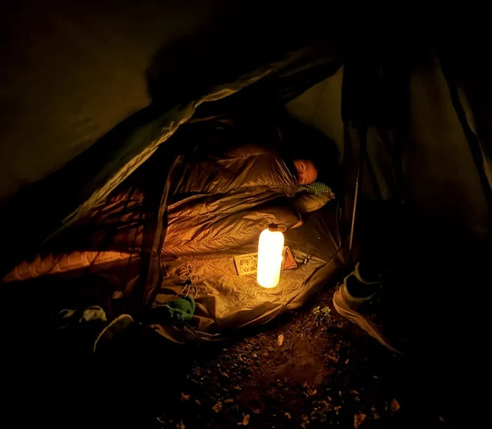 Alpenblow Lux Micro Inflator – glowing bottle lantern lighting a tent at night