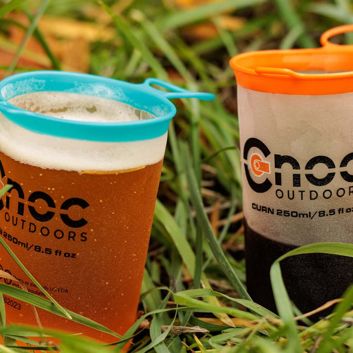 CNOC Curn Collapsible Cups holding drinks outdoors