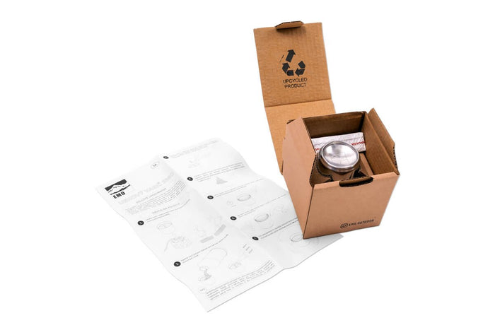 EMO Outdoor alcohol stove – open cardboard box with manual, studio view