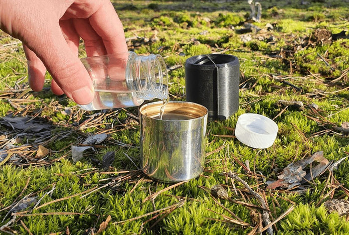 EMO Outdoor Capsule – hand opening the capsule outdoors on grass