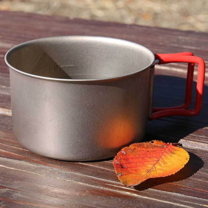 EVERNEW Ti Cup 400FD – titanium cup with red handle on a wooden table outdoors