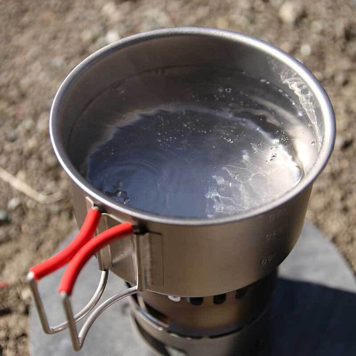 EVERNEW Ti Cup 570 – cup with water heating on a stove outdoors, top view