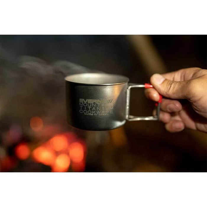 EVERNEW Ti Demitasse Cup 220 FH – cup held by hand beside a campfire outdoors