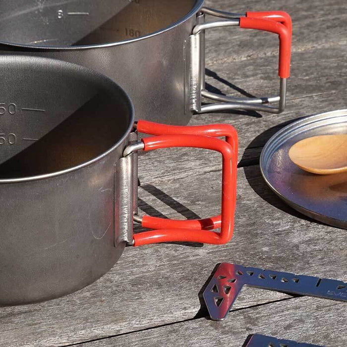 EVERNEW Ti Non-Stick Pot 600 – pot with red folding handles outdoors on wood