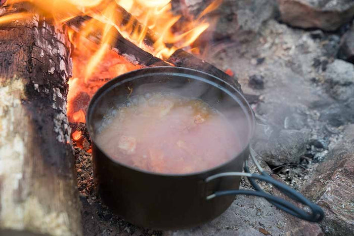 EVERNEW Ti Non-Stick Pot 900 – pot with food simmering over a campfire, outdoors