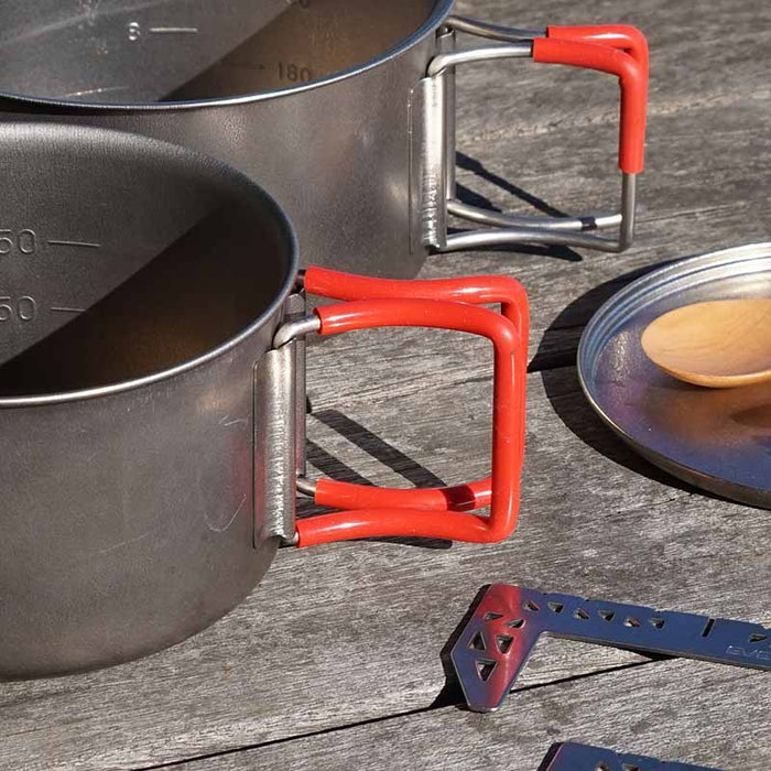 EVERNEW Ti Ultralight Pot 900ml – titanium pot with red handles used outdoors on wooden boards