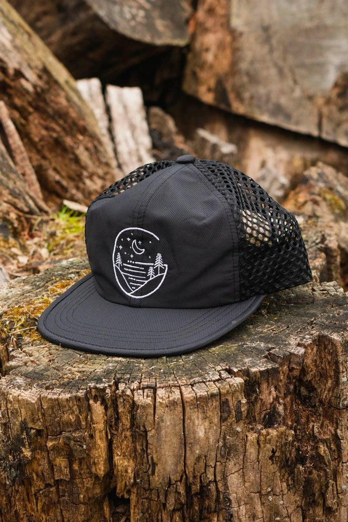 Glacial Gear Foldable Trail Hat in black with embroidered logo – on a tree stump