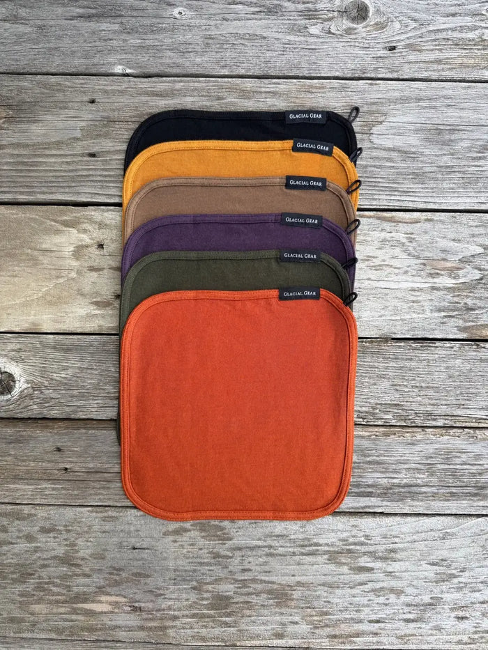 Glacial Gear Trail Rag Elite stacked in multiple colours, studio flat-lay on wood