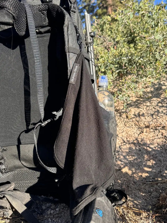 Glacial Gear Trail Rag Elite clipped to a backpack shoulder strap on the trail