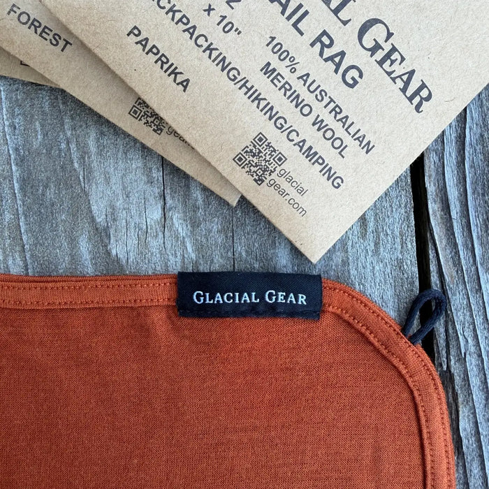 Glacial Gear Trail Rag Elite in paprika, corner detail with woven label and merino wool tag