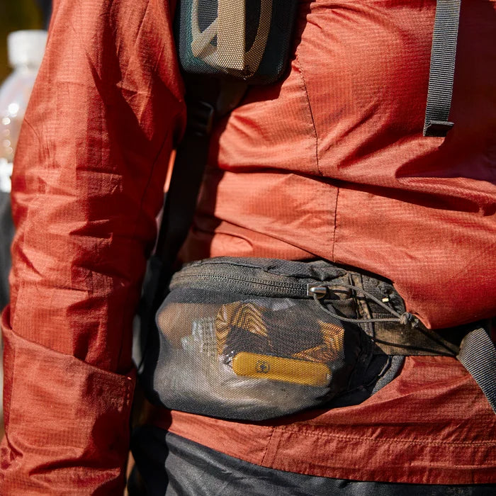 Gossamer Gear Fast Belt V2 worn at the waist, hands opening the mesh pocket with a knife inside