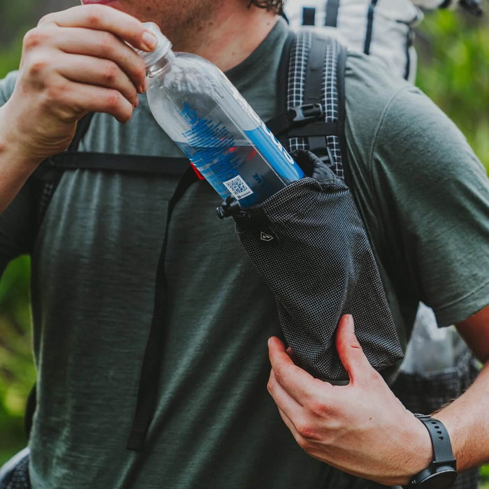 Hyperlite Mountain Gear Bottle Pocket – hiker lifting a water bottle out of the shoulder strap pocket