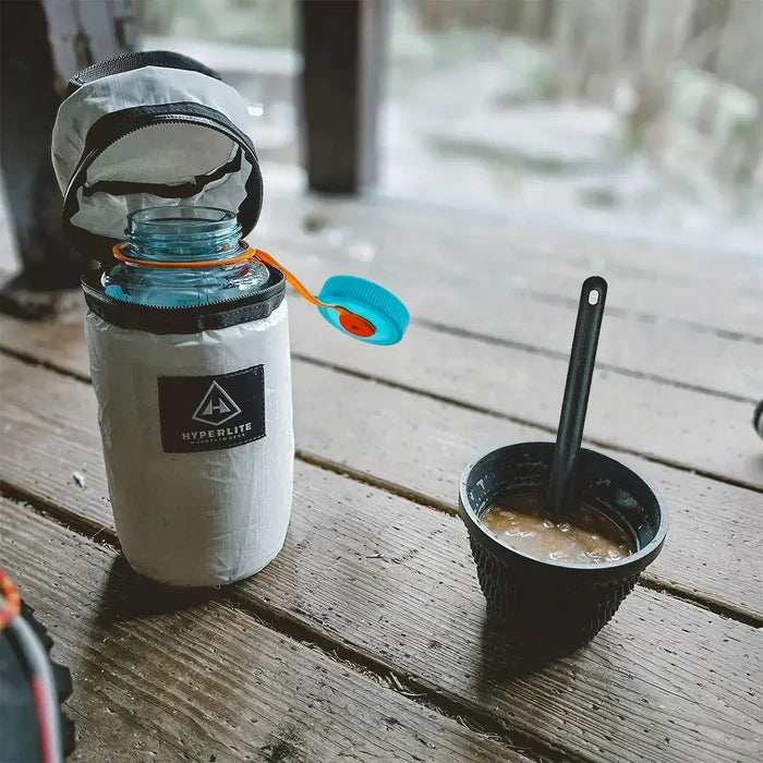 Hyperlite Mountain Gear Insulator held between mittened hands in the snow