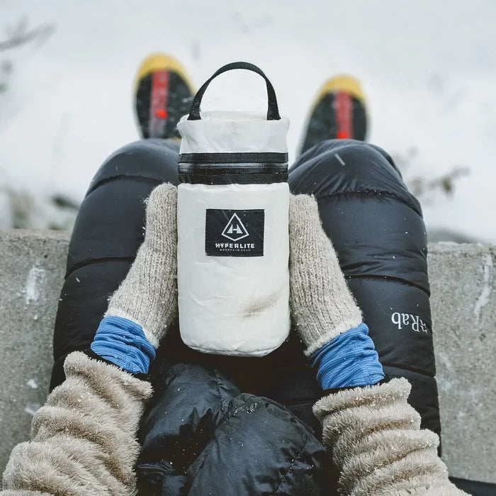 Hyperlite Mountain Gear Insulator clipped to a hiker's harness on a rocky trail