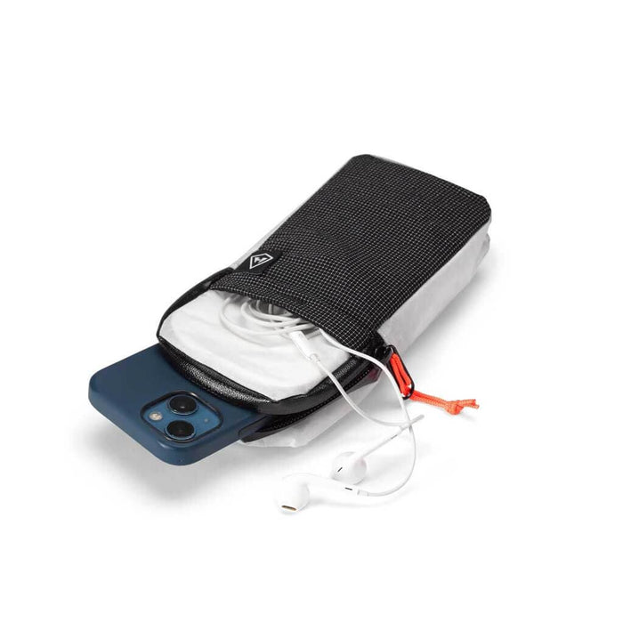 Hyperlite Mountain Gear Shoulder pocket open with a phone and earbuds spilling out, studio view