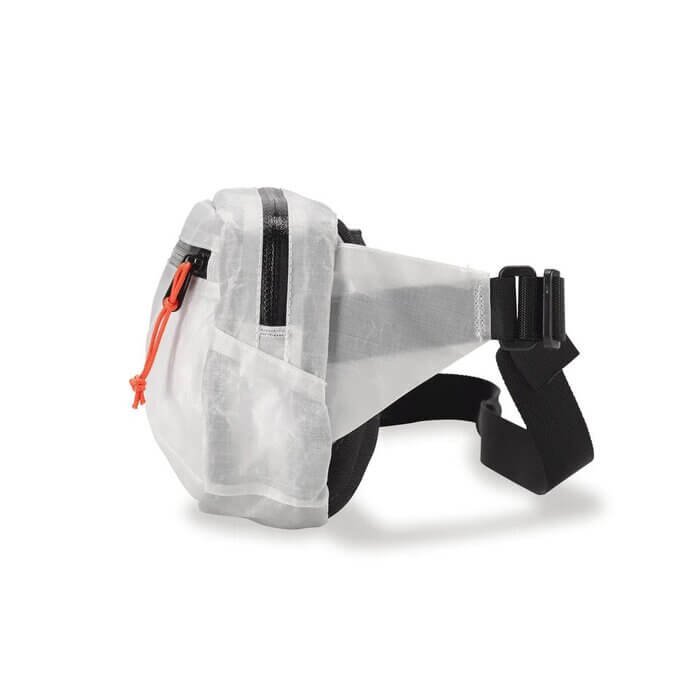 Hyperlite Mountain Gear Versa hip pack worn at the waist, hand reaching for a red phone case
