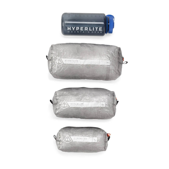 Hyperlite Mountain Gear Zippy pouches in three sizes next to a Hyperlite water bottle for scale