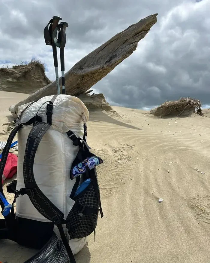 Läppie Pee Cloth in Fiesta print – clipped to a backpack on a beach