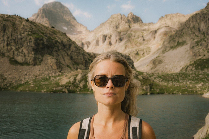 Ombraz Cammina armless sunglasses worn by a hiker at an alpine lake – front view