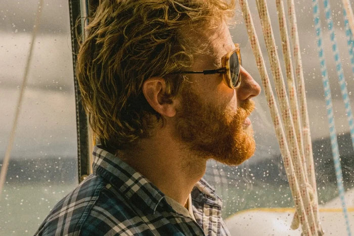 Ombraz Leggero armless sunglasses worn by a man in profile on a sailing boat