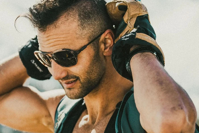 Ombraz Leggero armless sunglasses worn by a man with climbing gloves over the shoulder