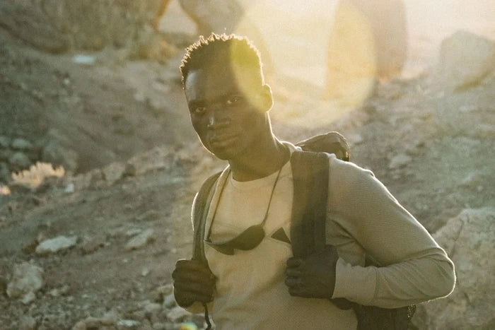 Ombraz Refugio armless sunglasses worn by a hiker with a backpack in bright sun