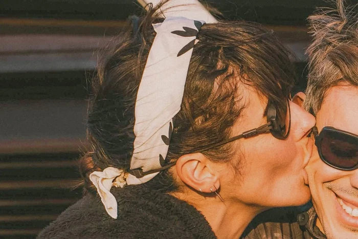 Ombraz Viale armless sunglasses, tortoise frame with grey lenses – worn by two people leaning close together