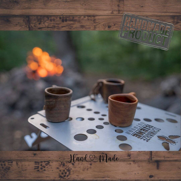 Outdoorline Handcrafted Wooden Shot Glass – on a camp table by the fire