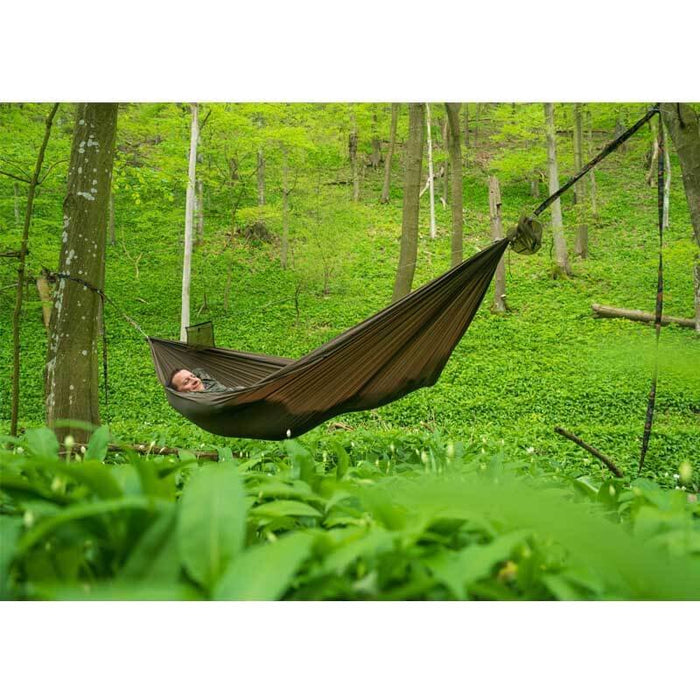 Outdoorline Orinoco ultralight hammock – pitched between trees in a green forest