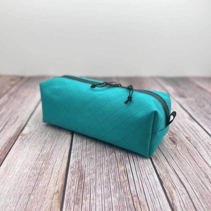 Outdoorline Zipper Pouch Long Ecopak – teal pouch on wood