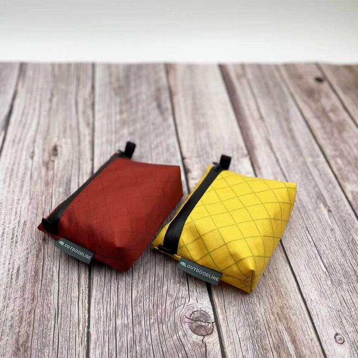Outdoorline Zipper Pouch Small Ecopak – red and yellow pouches on wood