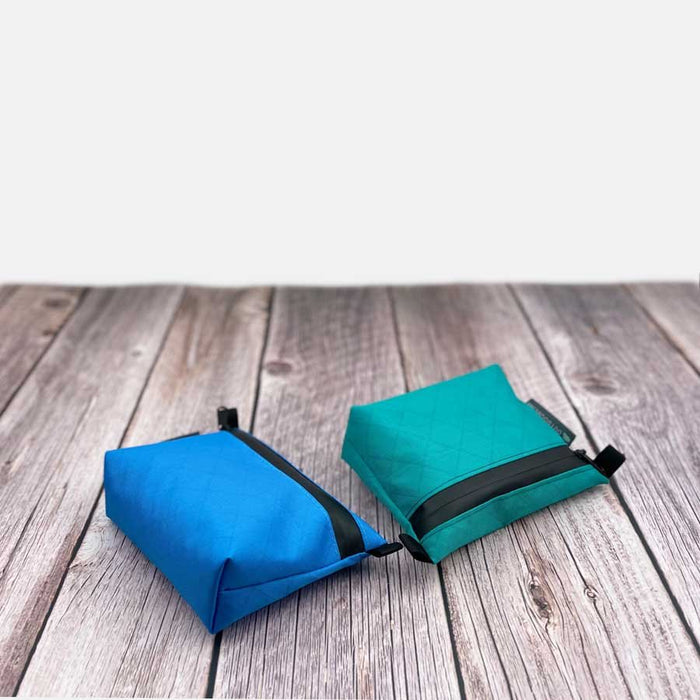 Outdoorline Zipper Pouch Small Ecopak – blue and teal pouches on wood