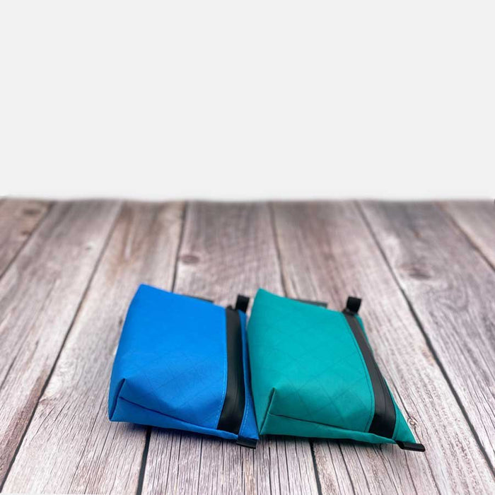 Outdoorline Zipper Pouch Small Ecopak – blue and teal pouches on wood