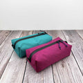 Outdoorline Zipper Pouch Wide Ecopak – teal and magenta pouches on wood