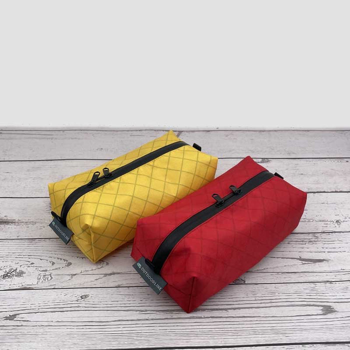 Outdoorline Zipper Pouch Wide Ecopak – yellow and red pouches on wood