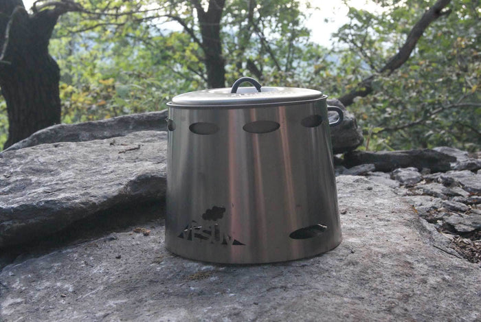 VESUV Titanium Windshield 1,3 L set up over a pot on a rock outdoors
