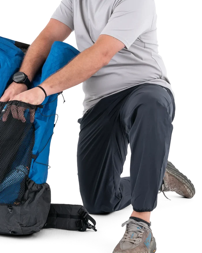 Zpacks Trail Cool Joggers in charcoal – worn kneeling by a backpack